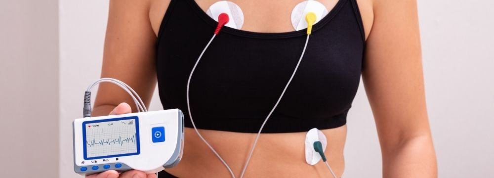 Woman wears an EKG monitor to track her heart over several days to diagnose arrhythmia like atrial fibrillation 